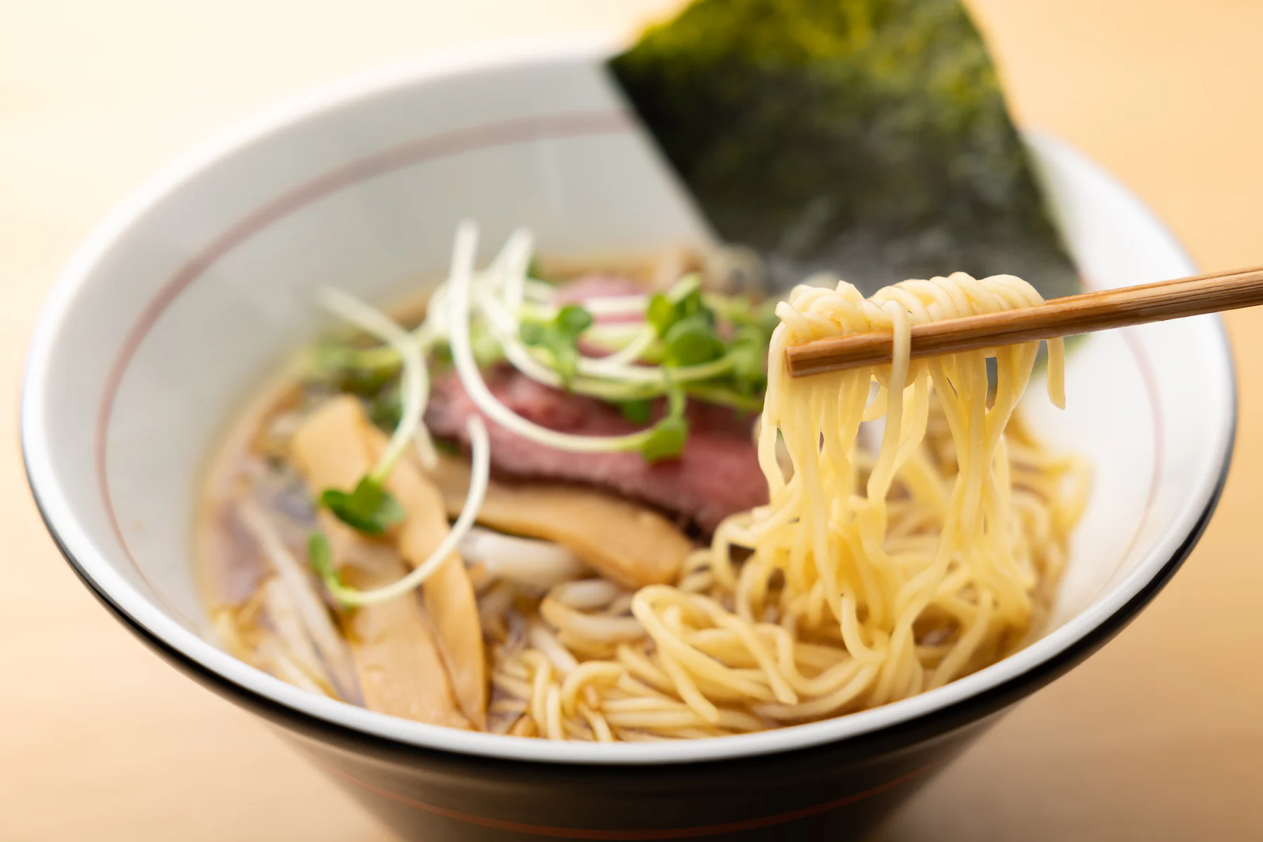 かめの中華そばから細麺を持ち上げる様子